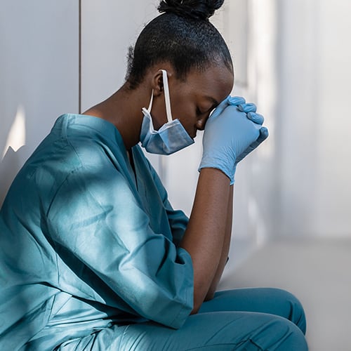 A nurse crouching against a wall