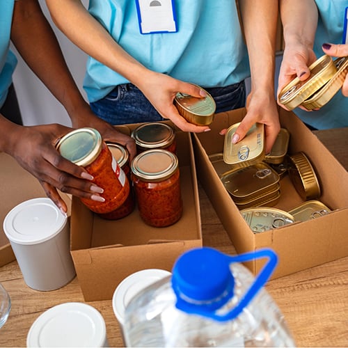 People assembling food into boxes
