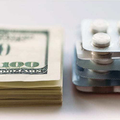 Cash money next to prescription pills
