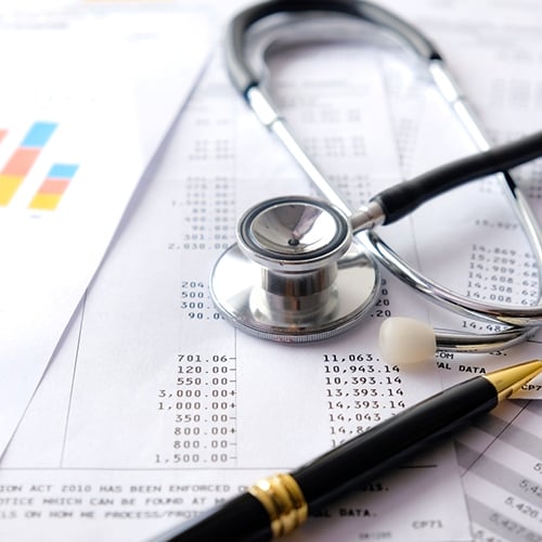 A stethoscope on top of a hospital bill